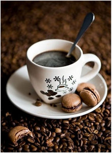 Diamond painting of a cup of coffee with macarons on a bed of coffee beans