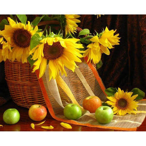 Diamond painting of a basket overflowing with sunflowers and red apples.