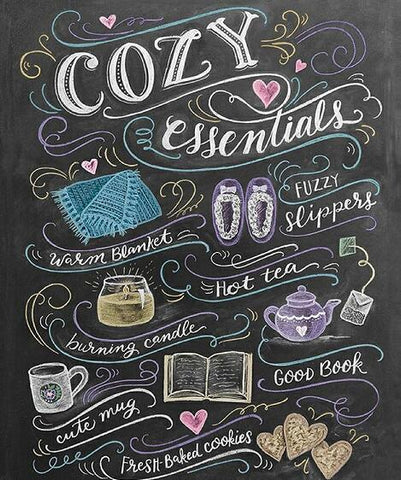 Image of Diamond painting of a chalkboard with the words "Cozy Essentials" surrounded by cozy-themed images, such as a blanket, slippers, hot tea, and a book.