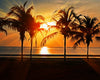 Diamond painting of a tropical beach at sunset, with palm trees silhouetted against a vibrant orange sky.