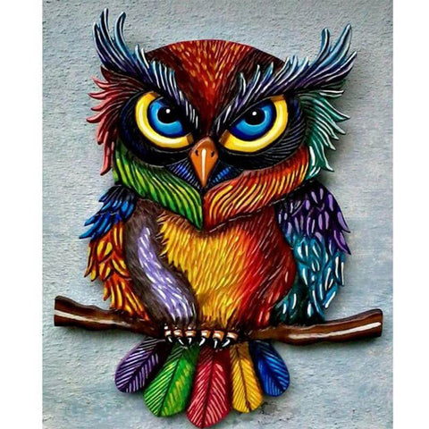 Image of Diamond painting of a colorful owl with big yellow eyes perched on a branch.