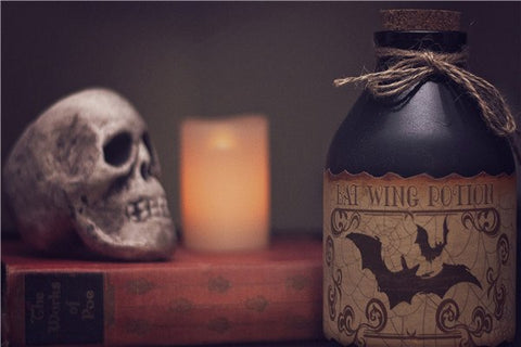 Image of diamond painting of a spooky potion bottle with a bat wing label and a skull