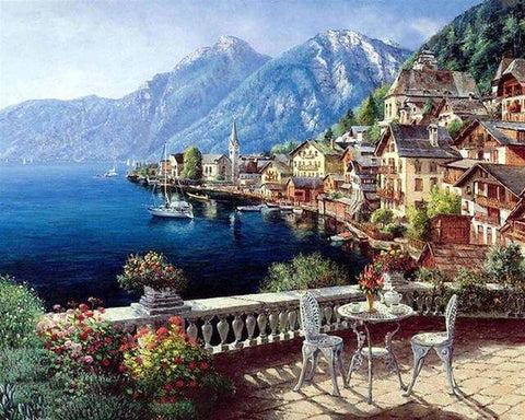 Image of Diamond painting of a scenic lakeside view from a balcony with a table and two chairs.