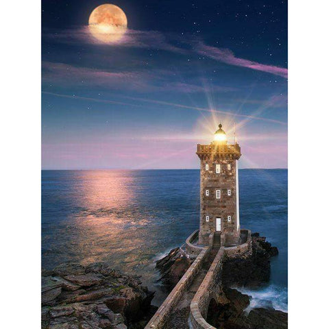 Image of diamond painting of a lighthouse shining brightly under the moonlight