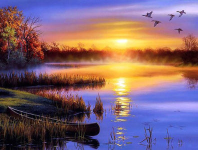 Diamond painting of a breathtaking sunset over a calm river, with evergreen trees silhouetted against the vibrant sky.