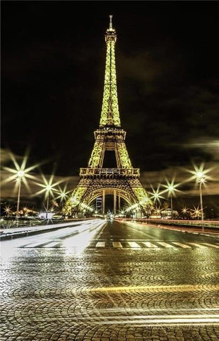 Image of Diamond painting of the Eiffel Tower illuminated at night, with the Seine River and bridge in the foreground