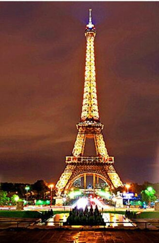 Image of Diamond painting of the Eiffel Tower illuminated at night, with the city lights in the background