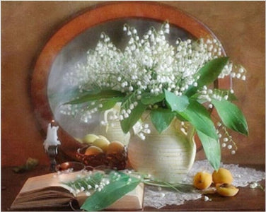 Diamond painting of lilies of the valley in a vase on a table with a book and candle