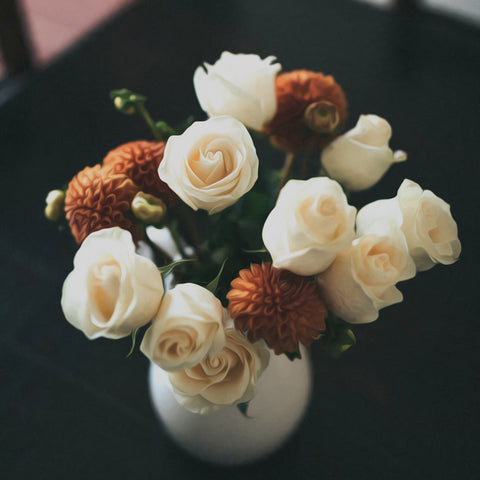 Image of Diamond painting of a white vase overflowing with a vibrant mix of roses and other colorful flowers.