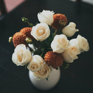 Diamond painting of a white vase overflowing with a vibrant mix of roses and other colorful flowers.