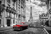 Red classic car parked in Paris street with Eiffel Tower in background.