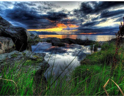 Image of Diamond painting of a colorful sunrise over a calm lake with mountains in the distance.