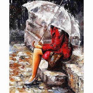 Diamond Painting of a Woman in a Red Coat Sitting Under an Umbrella in the Rain